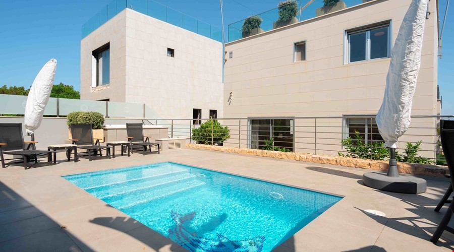 Light-filled two-bedroom loft style home for sale with sea-view roof terrace in gènova Elevated sea view townhouse with rooftop solarium & pool for sale in cala blava